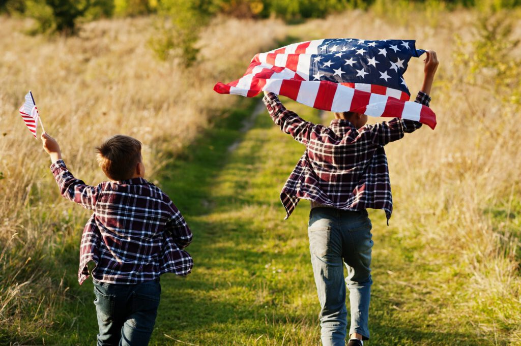 Two brothers running with USA flag. America holiday. Proud to be children of country.