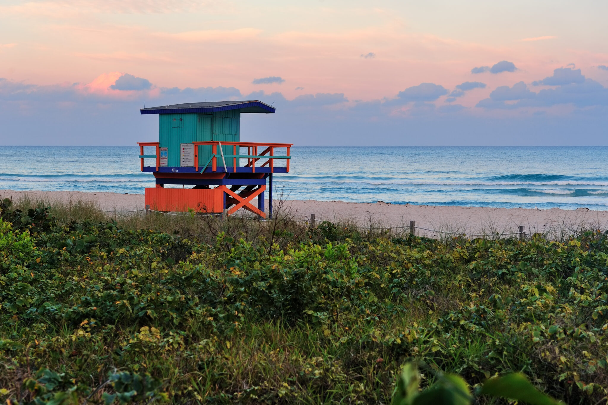 Farbenfroher Sonnenuntergang am Miami South Beach mit einem typischen Rettungsschwimmerturm und bunter Wolkenkulisse.